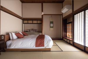 a bedroom with a bed in a room with windows at Shirafuji in Suzaka +26 photos