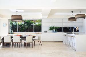 a kitchen and dining room with a table and chairs at The Peninsula Secret - spacious waterfront & heated Spa in Noosaville