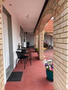 a patio with chairs and tables in a building at Taree Lodge Motel in Taree
