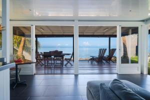 a living room with a view of the ocean at Fare Matairoa - 2BR Beach Cottage in Iumaru