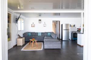 a living room with a couch and a table at Fare Matairoa - 2BR Beach Cottage in Iumaru