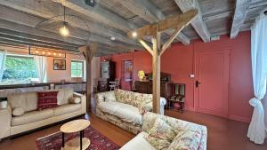 a living room with red walls and a couch at Lou peyrahout in Javerdat