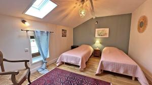 two beds in a room with a window at Lou peyrahout in Javerdat