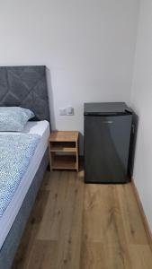 a bedroom with a bed and a night stand next to a table at Sobe Magnolija, self check-in in Vinkovci