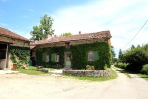 a house covered in ivy next to a street at Lou peyrahout in Javerdat
