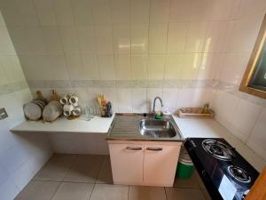 a small kitchen with a sink and a stove at Agro Camping Los Costeños in Choapa