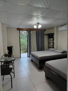 a bedroom with a bed and a table and a tableablish at Finca Kapok tree in Miramar
