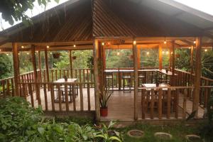 a wooden gazebo with tables and chairs on it at Finca Kapok tree in Miramar