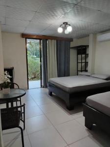a bedroom with a bed and a table in it at Finca Kapok tree in Miramar