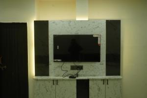 a flat screen tv on a wall in a room at Shri Hari Executive Lodge in Tuljapur