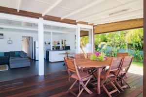 a dining room and living room with a table and chairs at Fare Matairoa - 2BR Beach Cottage in Iumaru