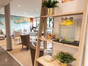 a shelf with glass jars and other items on it at Hotel Mercure Rennes Cesson in Cesson-Sévigné