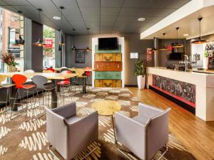 a restaurant with chairs and a table and a counter at ibis Nottingham Centre in Nottingham