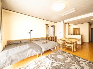 a bedroom with a bed and a table and a desk at The Global Tower in Niihama