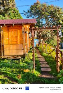 a small wooden house with a gate and a fence at wood house vattakanal in Kodaikānāl