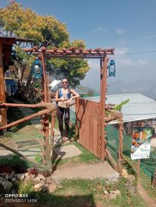a man is standing in a wooden archway at wood house vattakanal in Kodaikānāl +10 photos