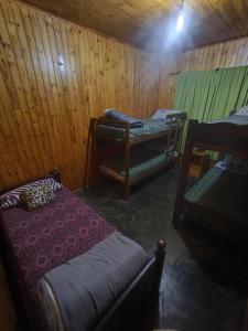 a room with two beds in a wooden cabin at Silvia Cabaña Confort in Puerto Iguazú