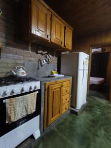 a kitchen with a stove and a refrigerator at Silvia Cabaña Confort in Puerto Iguazú