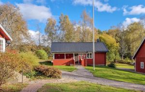 a red barn with a driveway leading to it at 2 Bedroom Nice Home In Örkeljunga in Orkelljunga +10 photos