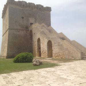 un gran edificio de ladrillo con una torre en Casa Vacanze Torre Lapillo en Torre Lapillo