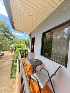 a balcony with a table and a chair on it at Chad's Lodge in Coron