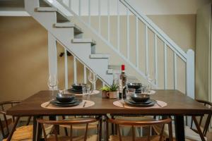 a dining room table with four chairs and a staircase at Naest - Authentic Escapes Old Town Villa Nijmegen in Nijmegen