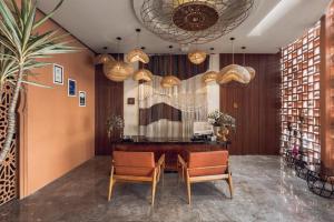 a lobby with a desk and chairs and lights at Cyrus Villa Seminyak by Ini Vie Hospitality in Seminyak +23 photos