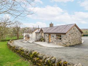 an old stone house with a driveway at Briws in Llangwm