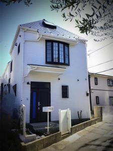 a white house with a black door and windows at Tsukui 347 B in Yokosuka