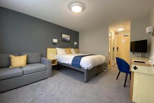 a hotel room with a bed and a couch at Days Inn Hotel Sedgemoor in Rooks Bridge