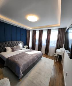 ein Schlafzimmer mit einem großen Bett, blauen Wänden und Fenstern in der Unterkunft David’s place in Floreşti + 119 Fotos