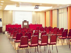 a conference room with red chairs and a podium at Hotel Mercure Siracusa in Syracuse +168 photos