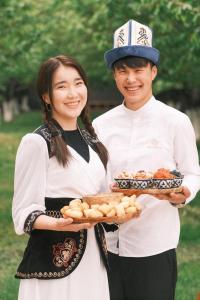a man and a woman holding a tray of food at Sunny Hostel in Osh +9 photos