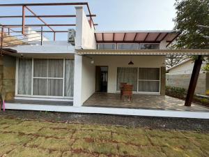 a house with a chair in front of it at Kimaya Cottage - 2BHK 1 Washroom in Trimbak