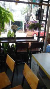 a table and chairs in a room with a window at J Cafe & Hostel in Chiang Mai +14 photos