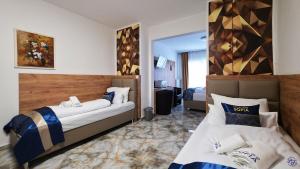 a hotel room with two beds and a mirror at Hotel Sofia in Bad Wildungen +146 photos