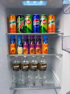 a refrigerator filled with cans of soda and drinks at Bella Vista Extended Stay in Kalyānpur