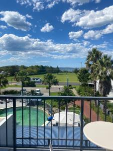 a balcony with a view of a golf course at Corrigans Beach Escape Studio in Batehaven +12 photos