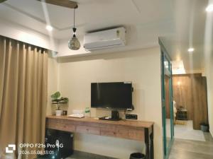 ein Wohnzimmer mit Fernseher und ein Schreibtisch mit Fernseher in der Unterkunft HOTEL ABHIJIt in Kolaghat