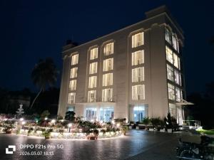 ein großes Gebäude mit Lichtern davor bei Nacht in der Unterkunft HOTEL ABHIJIt in Kolaghat