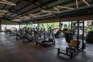a gym with a row of treadmills and machines at The Lario Collection - A Wellness Resort in Seminyak