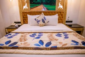 a bed with blue and white sheets and pillows at Emerald Bay Resort Mirissa in Mirissa