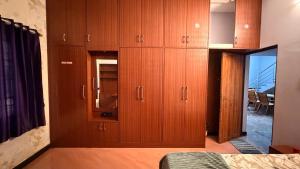 a bedroom with wooden cabinets and a bed with a mirror at Zeno Villa Malpe By Beach County in Udupi