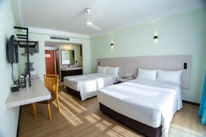 a hotel room with two beds and a television at Resorts World Langkawi in Pantai Cenang