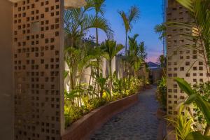 a walkway between two tall buildings with palm trees at Two Seasons Siem Reap Hotel in Siem Reap