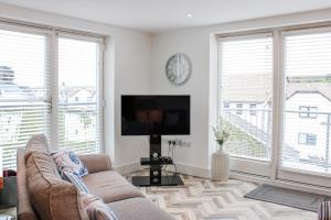 a living room with a couch and a flat screen tv at Estuary View in Kingsbridge