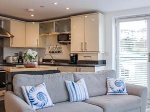a living room with a couch and a kitchen at Estuary View in Kingsbridge