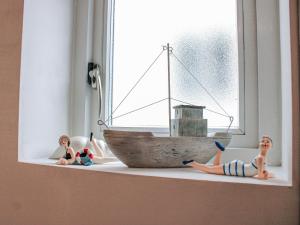 a toy boat sitting on a window sill with two dolls at Estuary View in Kingsbridge +27 photos