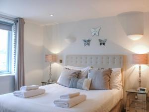 a bedroom with a white bed with towels on it at Estuary View in Kingsbridge