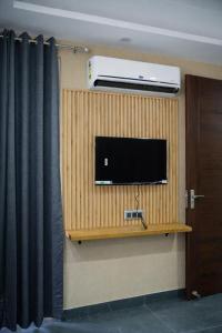 a flat screen tv on a wall in a room at Rudra Homestay - Rishikesh in Rishīkesh